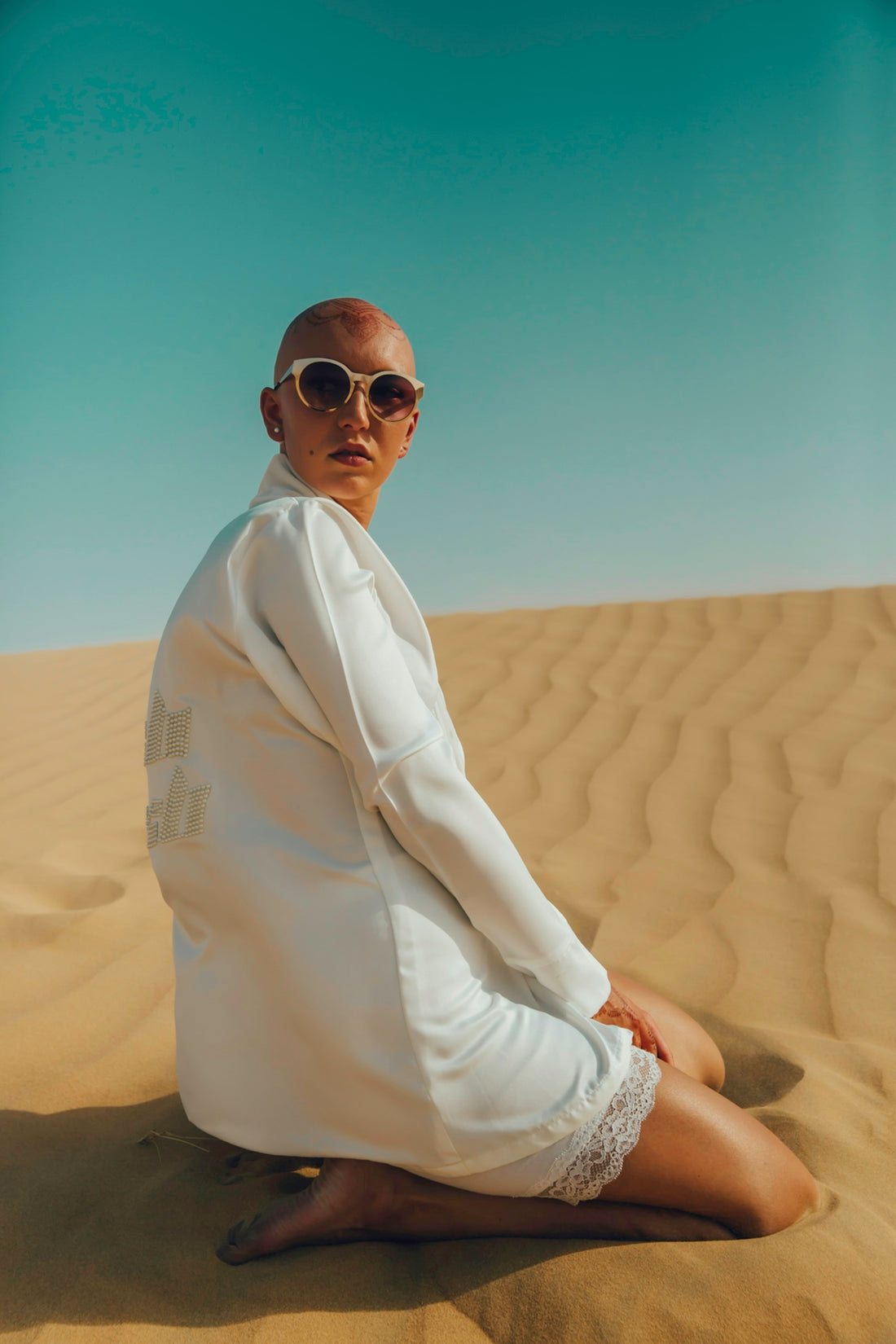 woman kneeling on brown sand taken at daytime