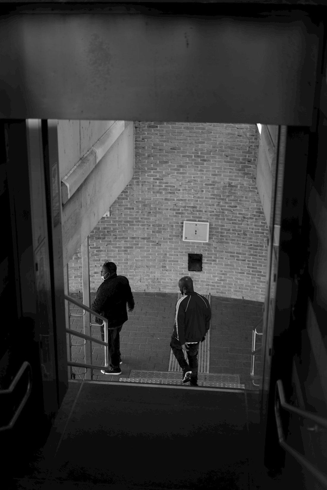 man in black jacket walking on hallway