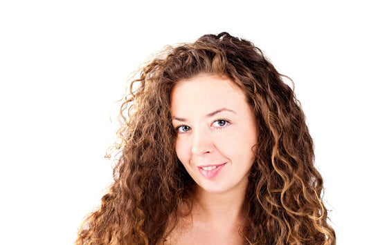 A woman with long curly hair posing for a picture